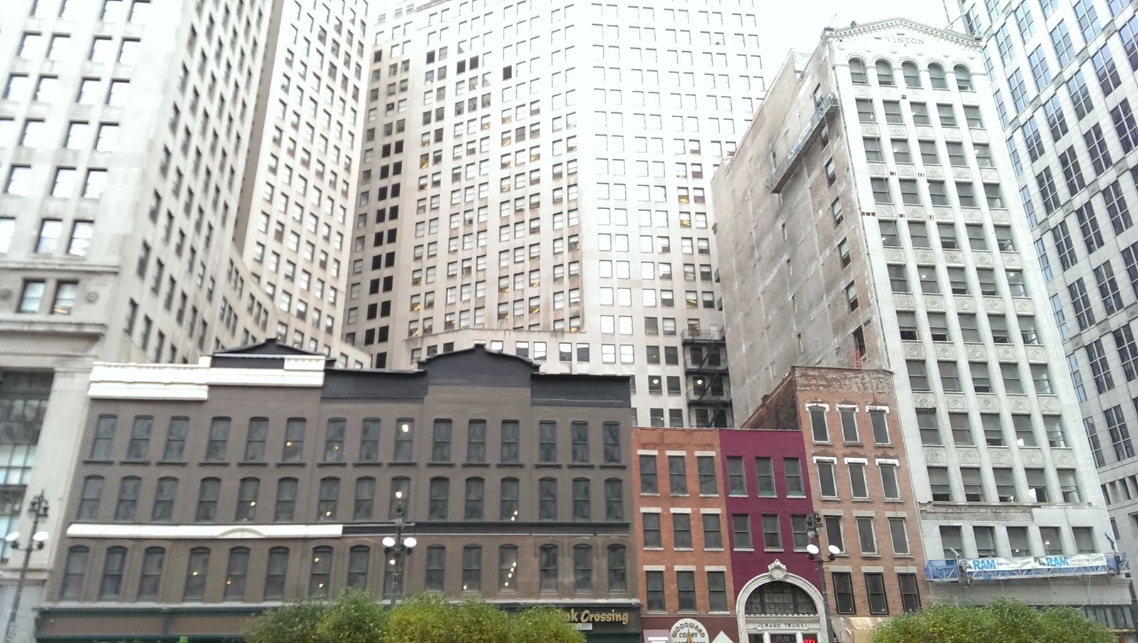 Photo of small buildings dwarfed by nearby skyscrapers in Detroit, Michigan