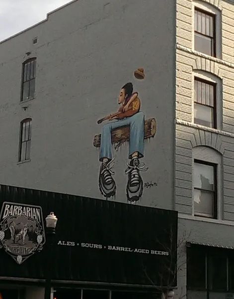 Photo of City Art, of a guitar player, jamming on a log, in Boise, Idaho