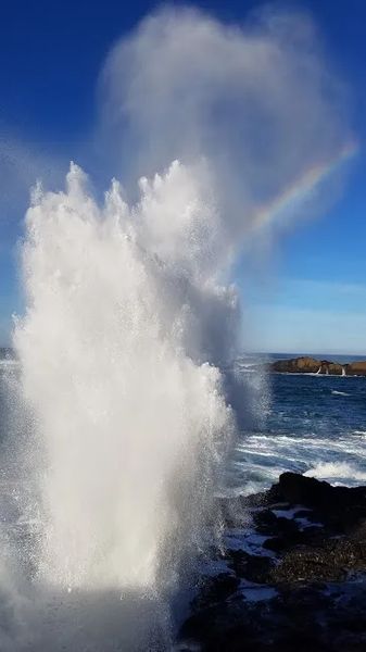 Photo of a water spout and rainbow from the surf in Depoe Bay, Oregon