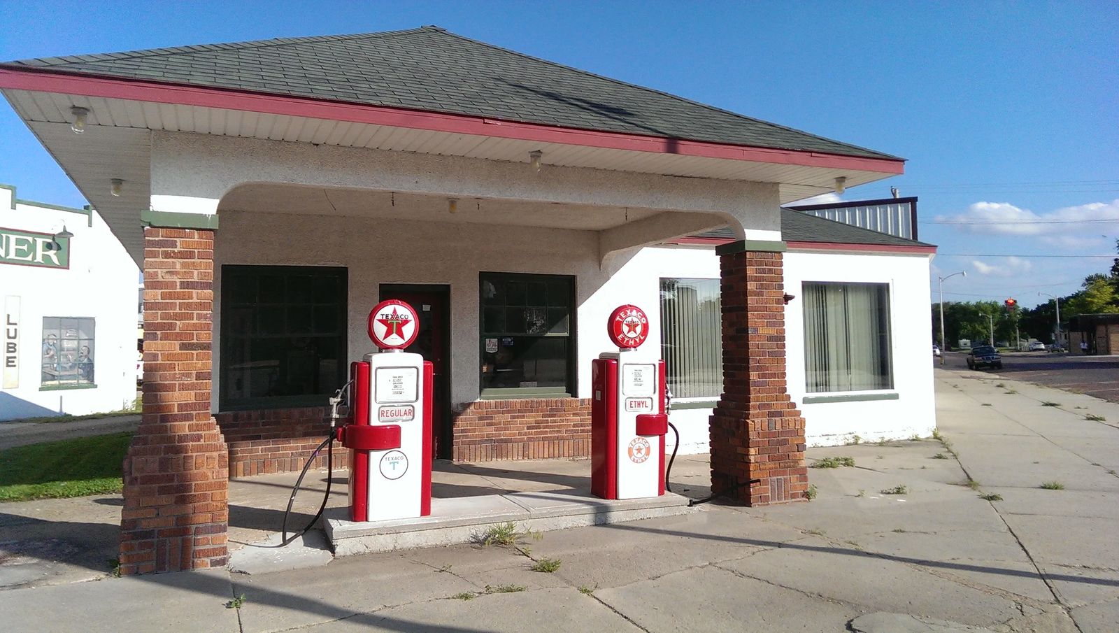 Photo of two antique gas pumps, one for Ethyl and one for Regular, in St. Paul, Nebraska