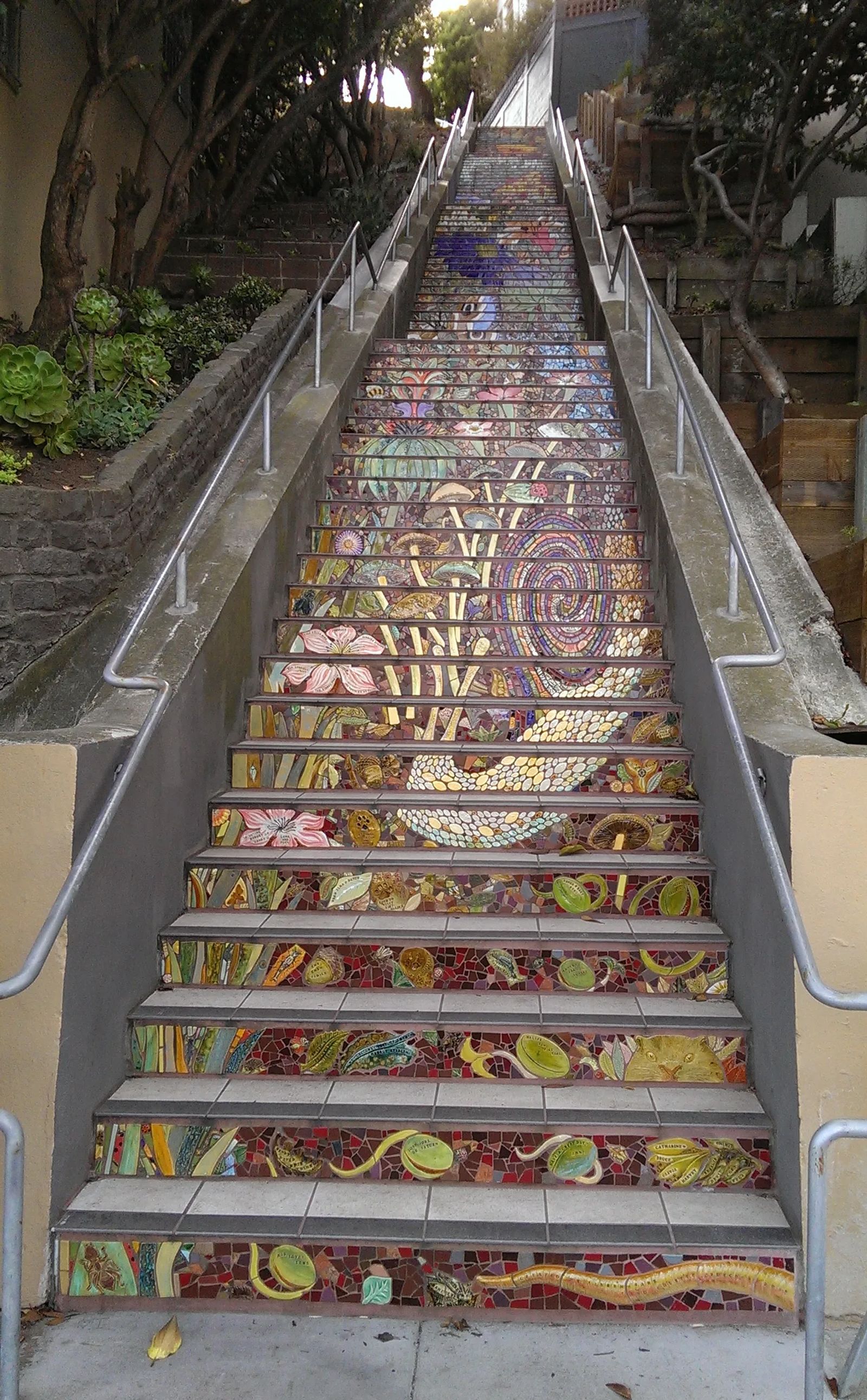 Photo of A cat peering from the mosaic at The bottom end of the hidden garden steps in San Francisco, California