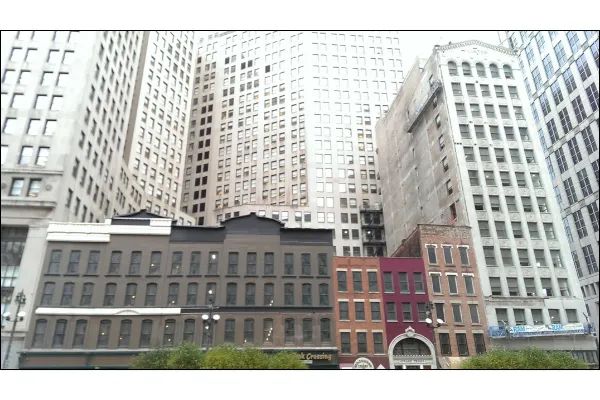 Photo of small buildings dwarfed by nearby skyscrapers in Detroit, Michigan