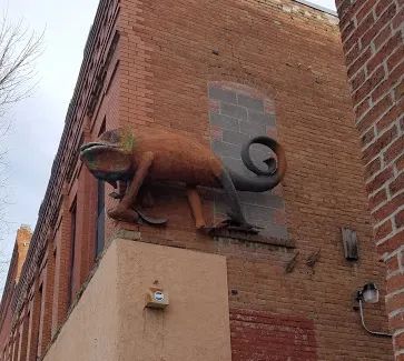 Photo of A giant chameleon climbing up the side of the building in Bozeman, Montana